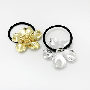 Detailed view of gold and silver alloy flower hair ties with high elastic black bands