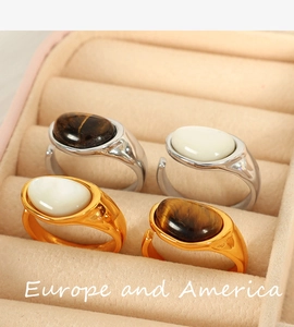 Detail view of 18k gold and silver plated rings with tiger eye and mother of pearl inlay