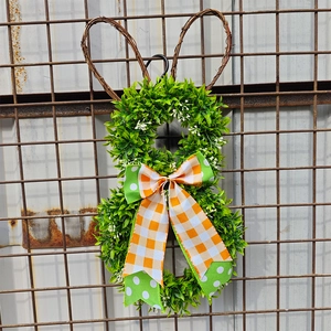 Detail of Easter bunny leaf wreath featuring a colorful patterned bow and twig ears