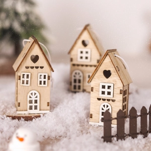 Three decorative wooden Christmas house ornaments displayed on snow with a festive background