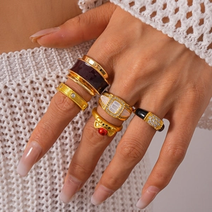 Detailed close-up of bohemian gold rings set with zircon and enamel on a model hand