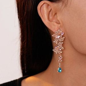 Close-up of elegant rose gold butterfly drop earrings with pink and blue crystal gems