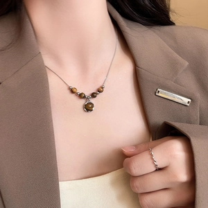 Detailed view of vintage tiger eye pendant necklace on model showing silk luster