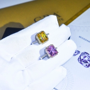 Luxury silver rings with yellow and pink square diamonds held by a gloved hand