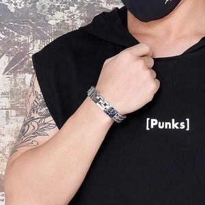 Detail of punk style titanium steel bracelet with blue geometric buckle on male model