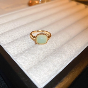 Close-up of gold-plated dragon ring with green square zircon in a white velvet box