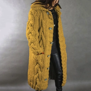 Detail of chunky cable knit pattern and large grey buttons on yellow hooded cardigan
