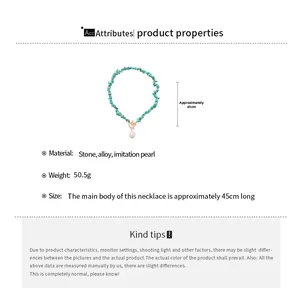 Detailed view of turquoise stone beads with a gold toggle clasp and drop pearl pendant