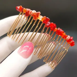 Dettaglio del pettine per capelli fatto a mano con pietre di cristallo rosso grezzo e oro