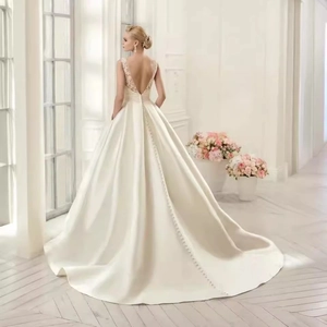 Elegant white backless wedding dress with lace details and a long satin cathedral train