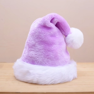 Detail of a purple plush Christmas hat with white faux fur pompom on wooden surface