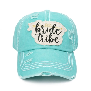 Detail of mint green washed baseball cap with bride tribe patch and distressed edge