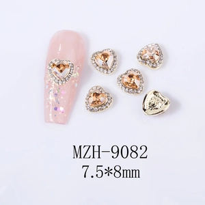 Macro view of champagne heart nail charms with white rhinestones and MZH-9082 size details