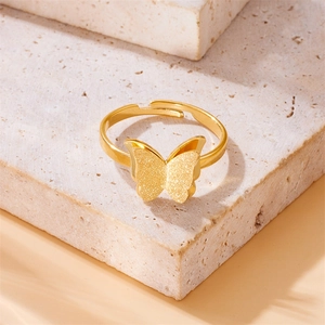 Adjustable golden stainless steel butterfly ring with a matte finish on a stone base