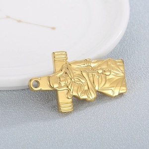 Golden stainless steel sleeping Buddha pendant with metallic luster on gray surface
