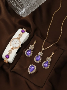 Detailed close-up of luxury gold watch set with purple teardrop gemstones on silk