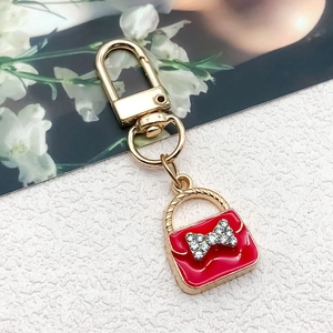 Detailed macro view of a red handbag keychain pendant with sparkling rhinestone bow