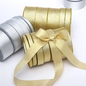 Detail of metallic gold and silver glitter ribbons showing woven texture and decorative bows