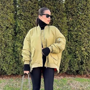 Détail d'un blouson aviateur oversize vert moutarde avec fermeture éclair et col côtelé