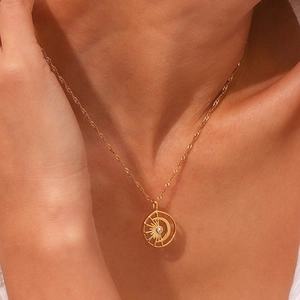 Close-up of 18K gold plated celestial pendant necklace with sun moon motif and zircon