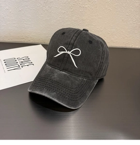 Détail d'une casquette de baseball en coton gris délavé avec nœud blanc brodé