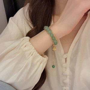 Close-up of beaded butterfly bracelet with green stones on a woman's wrist