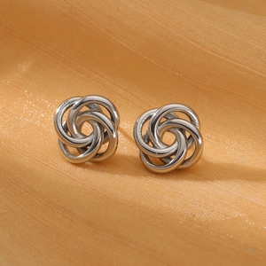 Detail of silver twisted knot stud earrings on orange silk background for a premium look