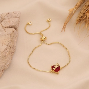 Detail of red heart pendant bracelet with adjustable gold chain and clear stone accents