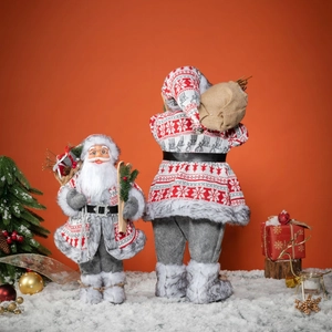 Plush Santa Claus figurines set with grey robes and skis on a red background