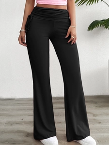 Détail du pantalon évasé noir à taille haute avec fronces et laçage latéral décoratif