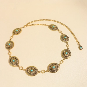Detail of vintage bohemian waist chain featuring golden sunburst metal plates and turquoise