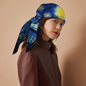 Detail of a silk scarf featuring Van Gogh Starry Night print worn by a model in a leather jacket