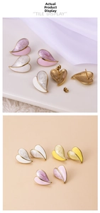Macro detail of geometric heart earrings with marble enamel texture and golden metal base