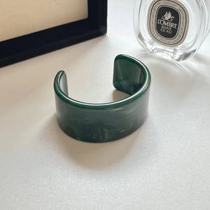 Details des dunkelgrünen Marmormuster-Acetat-Armreifs mit breitem offenem Design