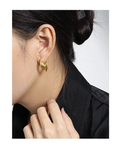 Close-up of minimalist multi-layer gold circle hoop earrings worn by a female model