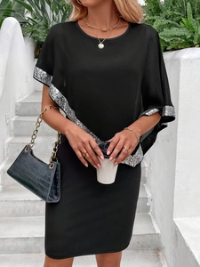 Detail of black knit dress with silver sequin cuffs and ribbed fabric texture close-up