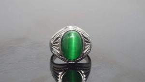 Detailed macro view of vintage silver steel ring with oval green cat eye gemstone