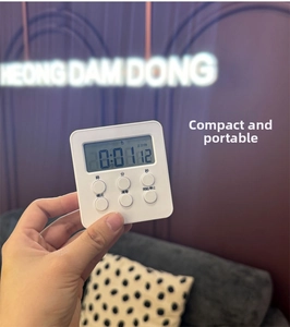 Handheld view of a compact white magnetic digital timer showing count-up mode