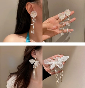 Detail of floral earrings with long pearl tassels and bowknot design for elegant style