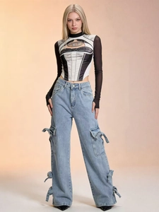 Detail of light blue wide-leg cargo jeans featuring side pockets and bow tie ribbons