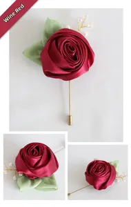 Detail of wine red satin rose boutonniere with green leaves and a white pearl pin