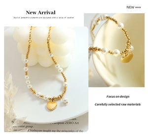 Detail of beaded pearl necklace with polished gold heart pendant and metallic beads