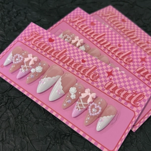 Handmade pink and white press-on nails with 3D bows, pearls, and heart details
