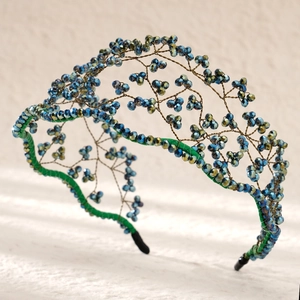 Macro detail of luxury bridal headband with woven blue beads and gold wire craft