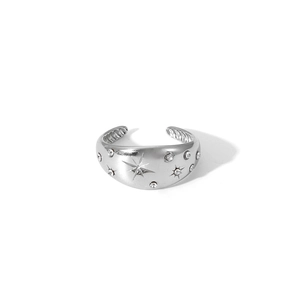 Close-up of silver adjustable ring featuring a starburst engraving and inlaid crystals