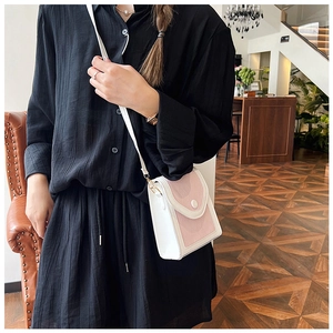 Détail du rabat rose matelassé et de la texture cuir blanc d'un mini sac bandoulière
