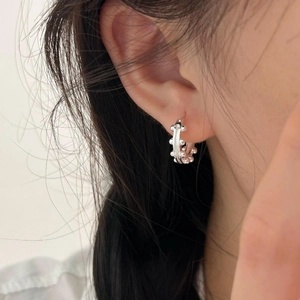 Close-up of minimalist 925 silver hoop earrings with delicate beaded texture on model