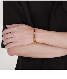 Close-up of golden Cuban link chain bracelet with polished and sandblasted finishes