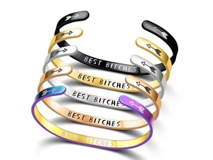 Macro shot of stainless steel C-shape cuffs in five colors with engraved inner text