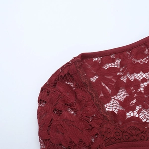 Detail of burgundy lace fabric featuring delicate floral patterns and fine mesh texture